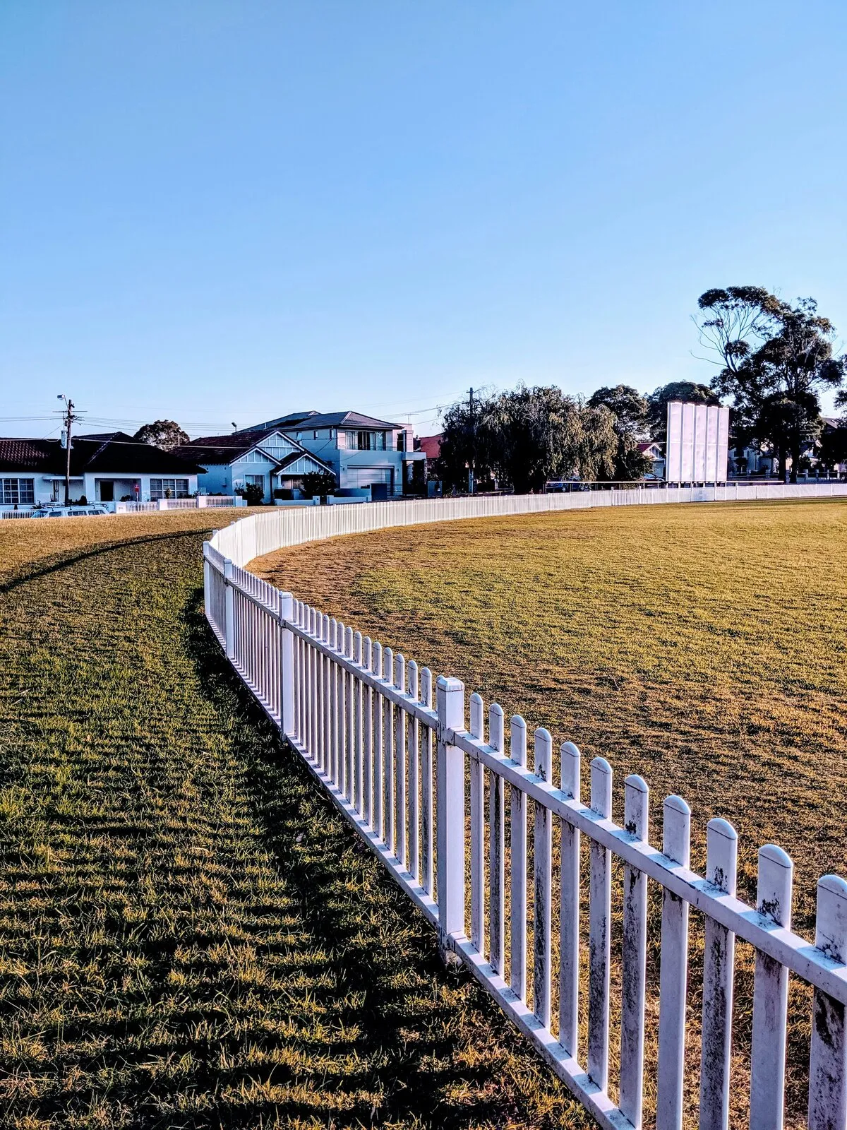 White vinyl fence panels along a property line, illustrative photo